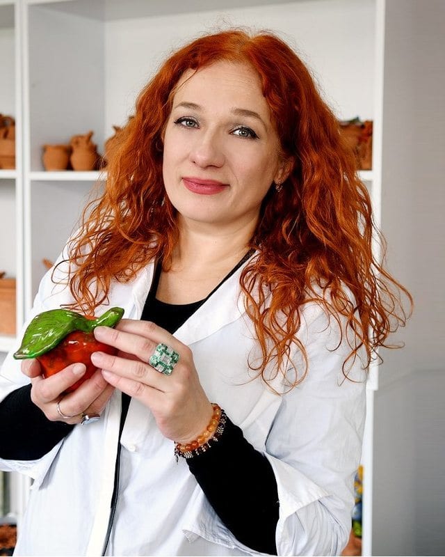 Инга Орехова в мастерской с керамическим яблоком в руках